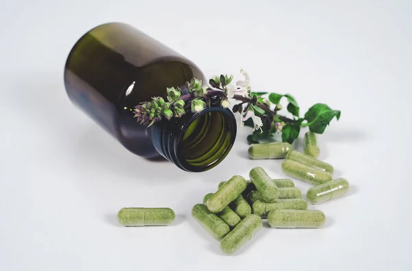 Alternative herb capsule spill out of bottle ,health concept. — Stock Photo, Image