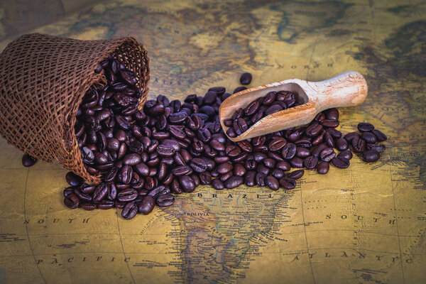 Wood spoon with coffee bean in sack bag on background.