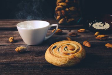 Çikolata parçacıklı Ekmek Denis ve ahşap sırtında sıcak kahve.