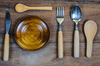 Tahta yüzey ve ahşap masa üzerinde tahta kaşık ve çatal..