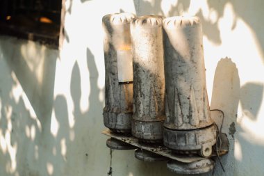 Kırık ve kirli su filtresi eski duvarda .