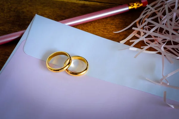 Duo anel de casamento dourado sobre invice card na mesa de madeira.Casamento c — Fotografia de Stock