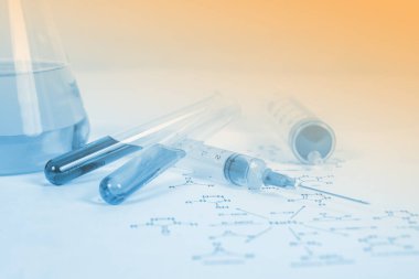 Şırıngada kırmızı bir solüsyon ve kimyasal formül arka planı, bilim konsepti