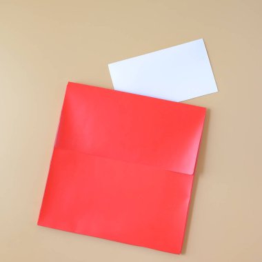 Renkli bir arkaplanda kırmızı kağıt zarf ve beyaz kart.