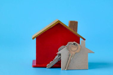 Ev şeklindeki anahtarlığı ve kırmızı evi olan anahtar çifti .