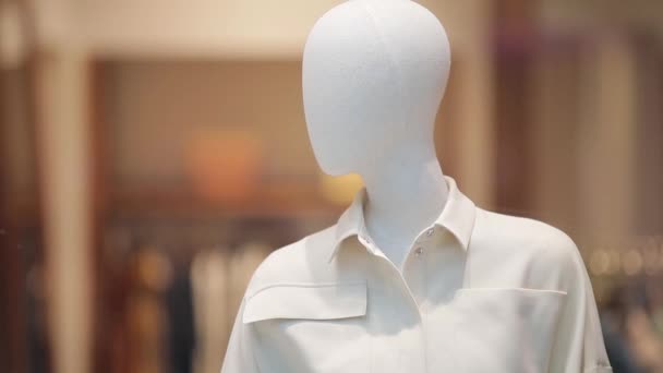 White mannequin in a white shirt on a store window. Shopping center, shops — Stock Video