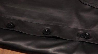 Siyah deri ceket, yakın plan. Düğmeleri olan deri bir ürün panoraması..
