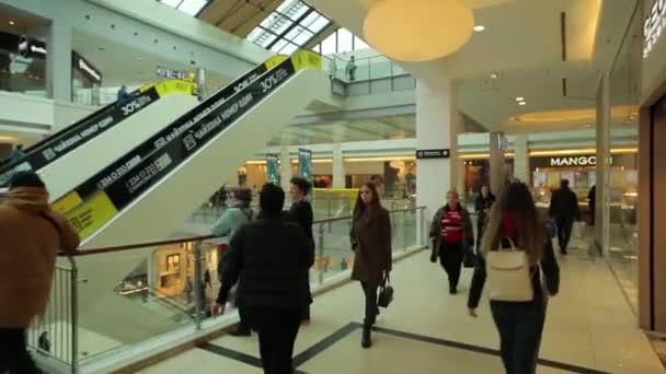 Um grande centro comercial, pessoas de diferentes idades e gêneros vão às compras — Vídeo de Stock