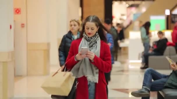 Um grande centro comercial, pessoas de diferentes idades e gêneros vão às compras — Vídeo de Stock