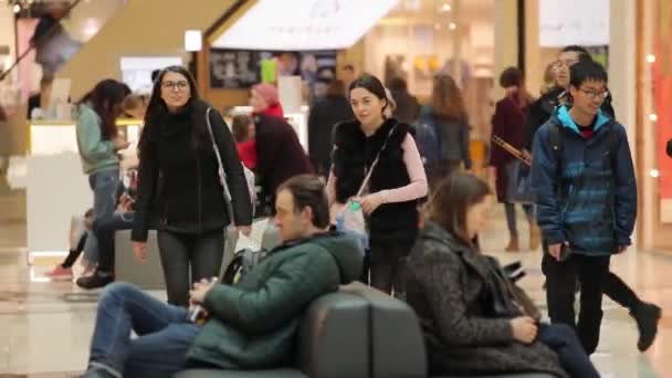 Ett stort handelscentrum, människor i olika åldrar och kön går och handlar — Stockvideo