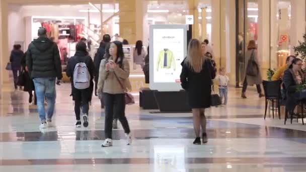 Geniş bir ticaret merkezi, farklı yaş ve cinsiyetlerden insanlar alışverişe gidiyor. — Stok video