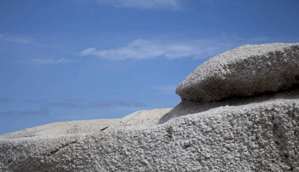 Large boulders on cloudy blue sky background. Royalty Free Stock Images