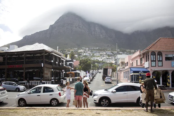Toeristen, locals op Camps Bay Street. Kaapstad. Stockfoto