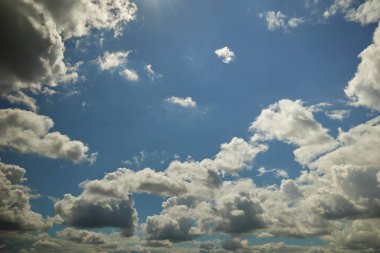 Cumulonimbus bulutları mavi gökyüzünde süzülüyor güneş ışınlarıyla aydınlanıyor