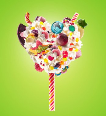 Tatlı Lolipop şeker, reçel, kalp önden görünüm ile krem şanti kalp şeklinde. Deli freakshake gıda eğilim. Çırpılmış krema lolly, berry ve jöleli şeker, çikolata tam kalbinde önden görünümü