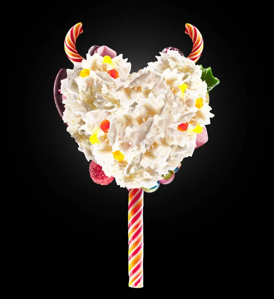 Corazón del diablo Batido de leche lolipop con dulces y crema batida, vista frontal. Dulce concepto de piruleta diabólica con crema batida y cuernos de diablo, sudores de diablo. Vista frontal de crema batida de dulces diablos — Foto de Stock