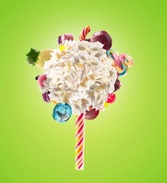 Crema chantilly batida concepto lolipop. Crema redonda batida de leche batida como piruleta con caramelos, dulces y dulces en la frontera, aislado en un fondo brillante. Crema remolino lolly con niños colorido — Foto de Stock