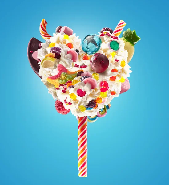 Sweet Lolipop v podobě srdce šlehačky s sladkosti, želé, pohled zepředu na srdce. Crazy freakshake potraviny trend. Čelní pohled šlehačkou srdce krém lízátko, plný berry a želé bonbóny, čokoláda — Stock fotografie