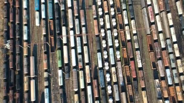 航空工業製品と石油化学製品の配信を待っている色貨物列車を示す領空侵犯して車庫 進む空中の動きの複数のトラックに駐留 — ストック動画