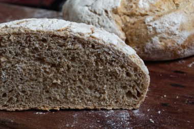 Taze ev yapımı zanaatkar ekmeği sepetin içinde ahşap masanın üzerinde.