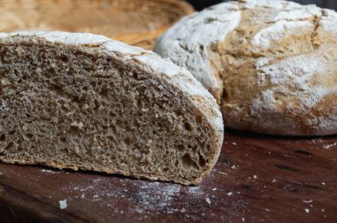 Taze ev yapımı zanaatkar ekmeği sepetin içinde ahşap masanın üzerinde.