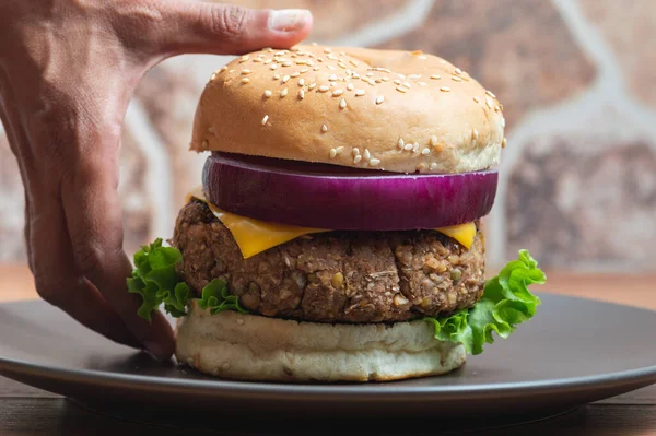 Womans hands picking up a vegetarian burger