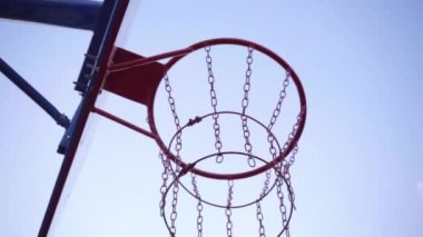 Arka planda basketbol şapkası. Topun yakın çekimi basket potasına uçar. Yavaş çekim.