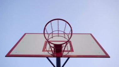 Arka planda basketbol şapkası. Topun yakın çekimi basket potasına uçar. Yavaş çekim.