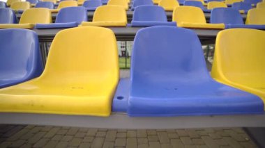 4K, Stadyumdaki Boş Plastik Koltuklar. Seyirci ve Hayranları Olmayan Futbol Stadyumu Tribününde Sarı ve Mavi Koltuklar