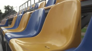 4K, Stadyumdaki Boş Plastik Koltuklar. Seyirci ve Hayranları Olmayan Futbol Stadyumu Tribününde Sarı ve Mavi Koltuklar
