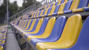 4K, Stadyumdaki Boş Plastik Koltuklar. Seyirci ve Hayranları Olmayan Futbol Stadyumu Tribününde Sarı ve Mavi Koltuklar