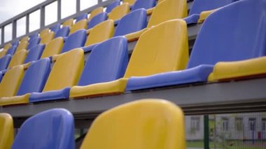 4K, Stadyumdaki Plastik Koltuklar Boş. Seyirci ve Hayranları Olmayan Spor Arenası Tribününde Sarı ve Mavi Koltuklar