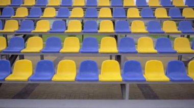 4K, Stadyumdaki Plastik Koltuklar Boş. Seyirci ve Hayranları Olmayan Spor Arenası Tribününde Sarı ve Mavi Koltuklar