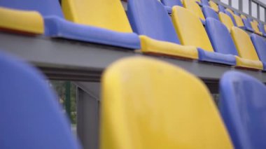 4K, Stadyumdaki Plastik Koltuklar Boş. Seyirci ve Hayranları Olmayan Spor Arenası Tribününde Sarı ve Mavi Koltuklar