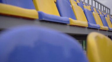 4K, Stadyumdaki Plastik Koltuklar Boş. Seyirci ve Hayranları Olmayan Spor Arenası Tribününde Sarı ve Mavi Koltuklar