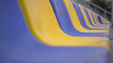 4K, Stadyumdaki Plastik Koltuklar Boş. Seyirci ve Hayranları Olmayan Spor Arenası Tribününde Sarı ve Mavi Koltuklar