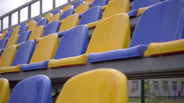 Leere Reihen Von Plastiksitzen Stadion Gelbe Und Blaue Sitze Auf — Stockvideo