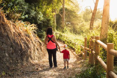 Anne ve oğlu tarlada yürüyor.