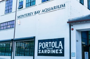 Monterey Körfezi Akvaryumu logosu ve Cannery Row rıhtım caddesinde kar amacı gütmeyen bir akvaryum reklamı. Portola marka Sardalya reklamı - Monterey, California, ABD - 2019