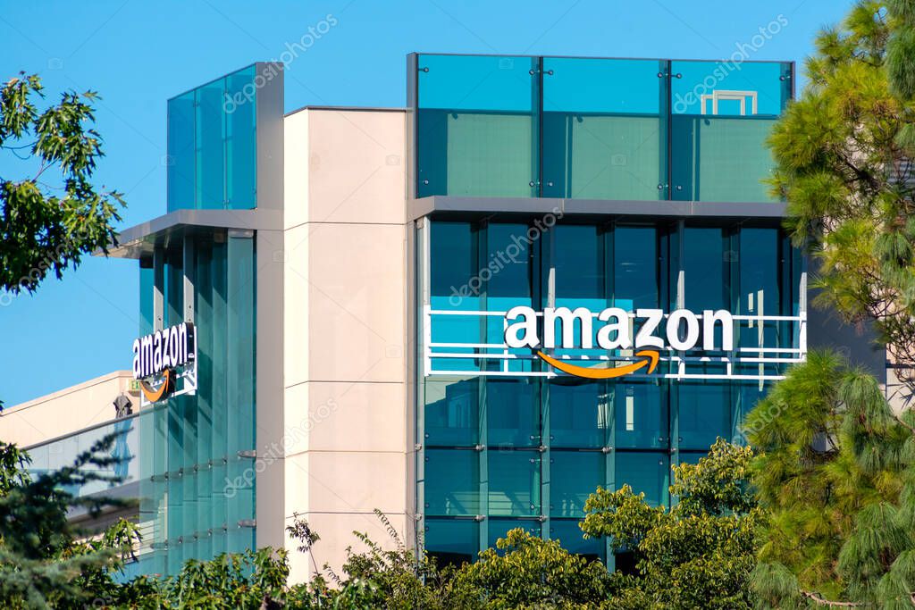 Amazon office building facade surrounded by green trees under blue sky - Palo Alto, California, USA - 2020