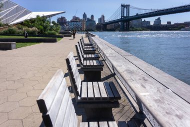 East River Rıhtımı 35. iskelede. New York, Aşağı Doğu Yakası 'ndaki rıhtım boyunca boş ahşap banklar.