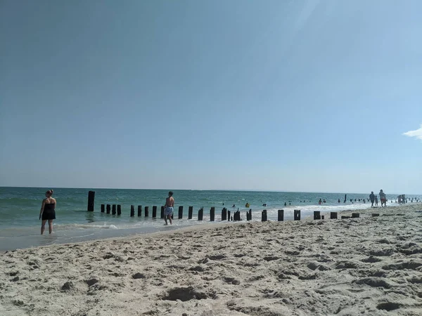 Postes Madera Restos Embarcadero Una Playa Arena Gente Caminando Por —  Fotos de Stock