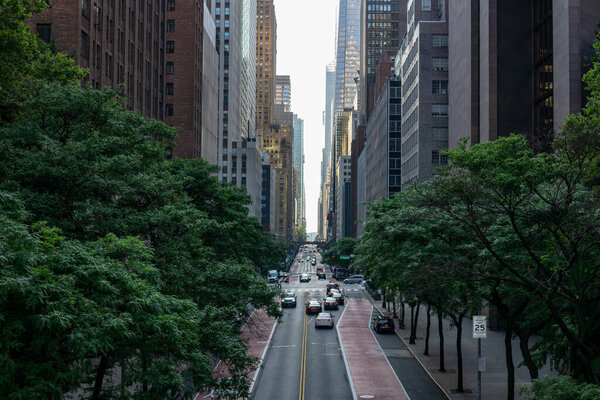 Above view on a new york city street. Skyscrapers, commercial and residential buildings. Trees area
