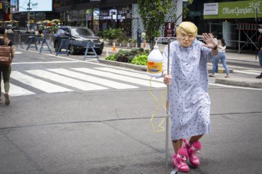 New York / ABD - 10 Ekim 2020: Amerikan Başkanı Donald Trump 'ın kauçuk maskesine sahip bir kişi ve üzerinde çamaşır suyu şişesi olan bir hastane önlüğü