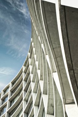 Güneşli bir günde mavi gökyüzü olan modern apartmanların alçak açılı görüntüsü. Modern bir apartmanın cephesi