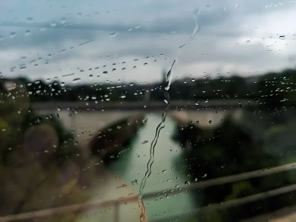water droplets on glass window during raining with blurry background
