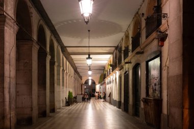 Girona - 20 Temmuz 2025, İspanya 'nın Girona kentindeki Independence Meydanı' nda restoranları olan geçitte simetrik sütunlar