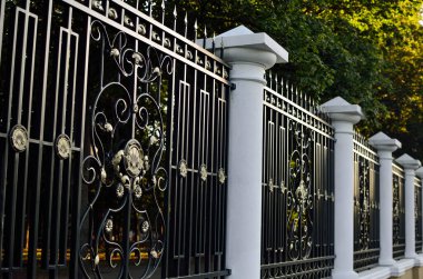 forged fences with columns in the park clipart