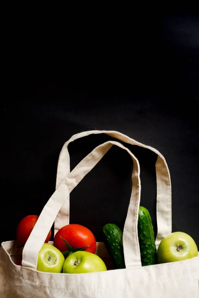 Baumwolltasche mit frischem, hellen Gemüse auf schwarzem Hintergrund. — Stockfoto