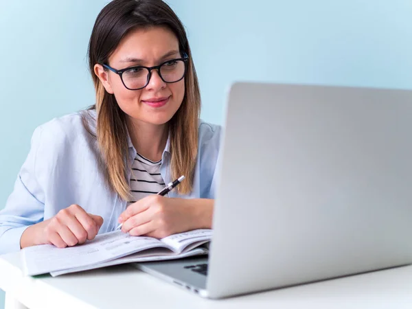 Дистанционное обучение онлайн. Женщина учится с ноутбуком, смотрит вебинар — стоковое фото